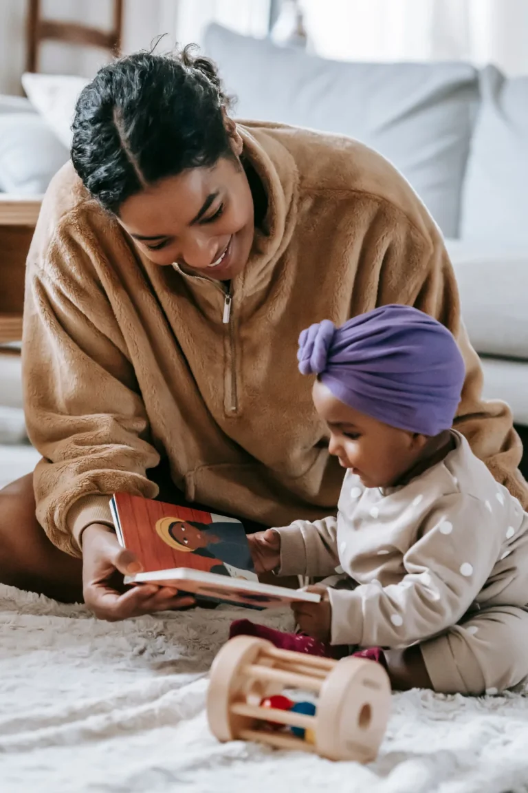 Mamma che legge un libro illustrato con una bambina piccola
